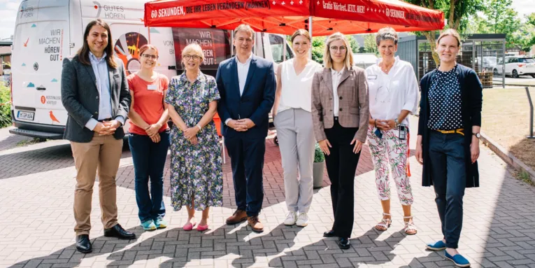 Acht Menschen präsentieren sich an einem Infostand